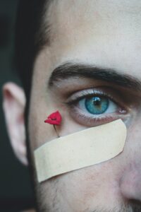  man with a bandage to symbolize healing with herbalism and mutual aid.